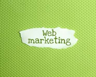 a torn paper written with inscription Web marketing on a green background