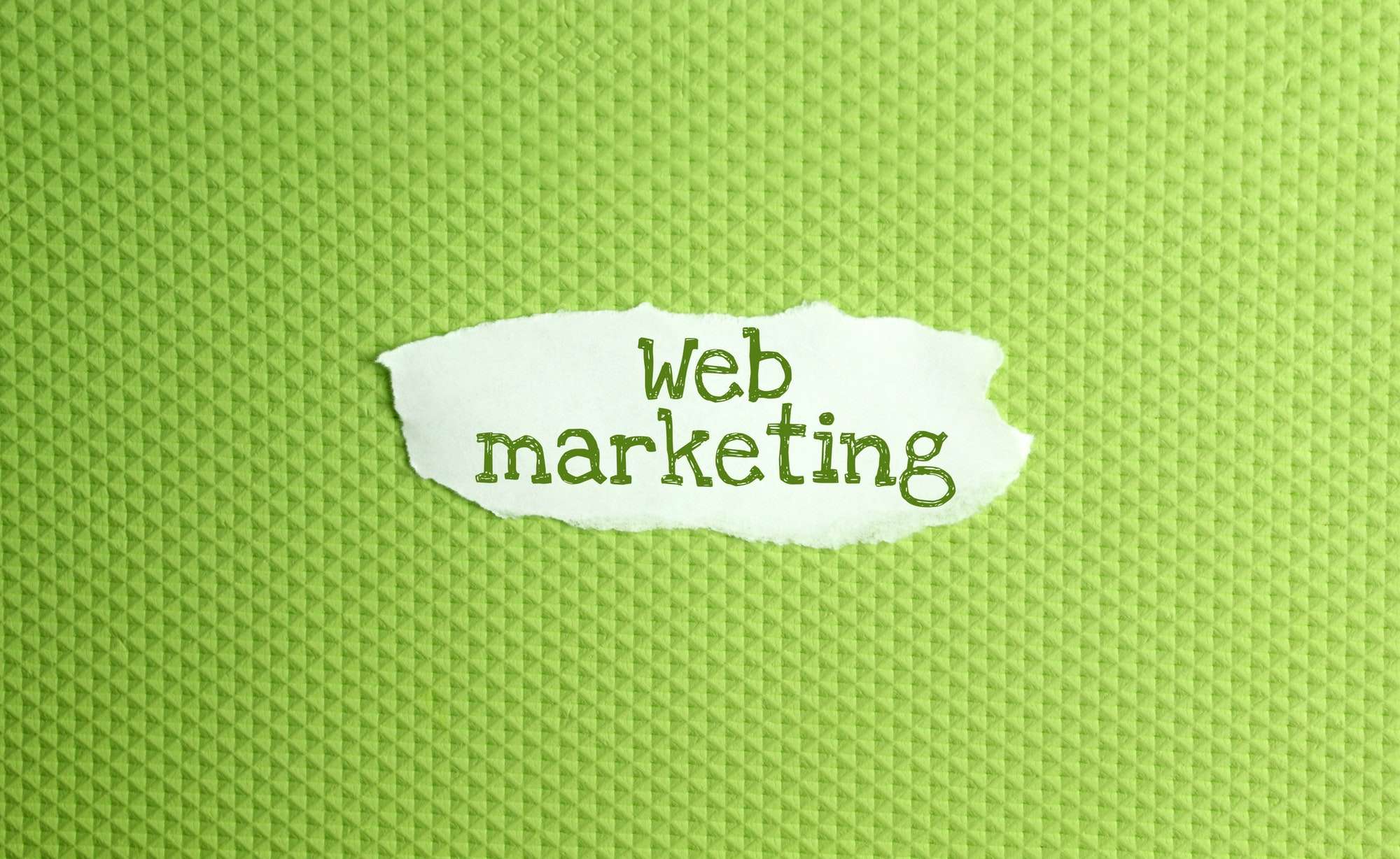 a torn paper written with inscription Web marketing on a green background