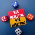 Colored board and dice with the word WEB MARKETING. Business concept