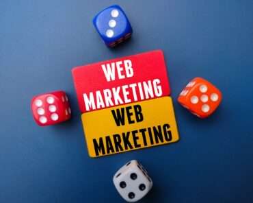 Colored board and dice with the word WEB MARKETING. Business concept