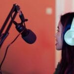 Empowering Voices: Asian Woman Smiling while Podcasting