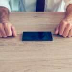 Businessman fighting mobile phone addiction crisis