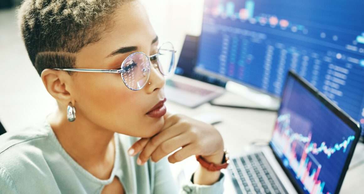 Computer, trading and face of professional woman reading fintech company metrics, banking numbers o
