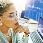 Computer, trading and face of professional woman reading fintech company metrics, banking numbers o