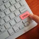Finger pressing keyboard label VIRAL.