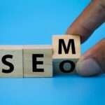 wooden cube with the letters SEM or SEO.